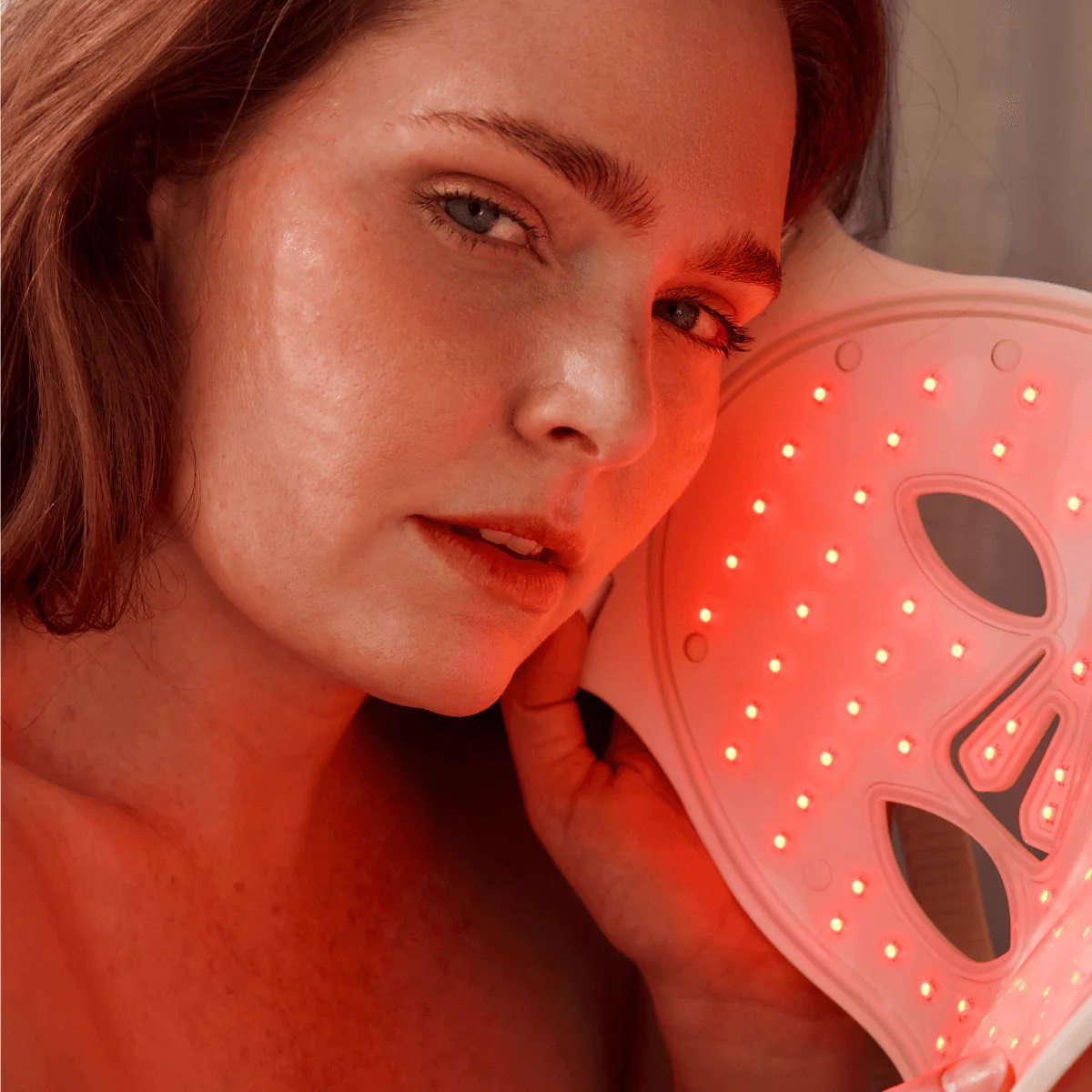 woman with red light therapy mask